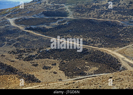 Rocky strada sterrata nel deserto della Giudea deserto come visto da Mt. Scopus in Gerusalemme, Israele con fumoso montagne sullo sfondo. Foto Stock