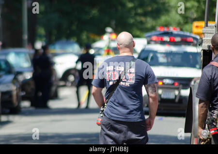 E 229 st Ed Carpenter street, Bronx, New York, Stati Uniti d'America. Il 9 agosto, 2017.un vigile del fuoco guarda come condotta da parte della polizia di un inchiesta sugli incidenti per un ambulette che appoggiato su una donna che era il funzionamento del veicolo in corrispondenza di E 229 st Ed Carpenter street. Michael Glenn / Alamy Live News Foto Stock