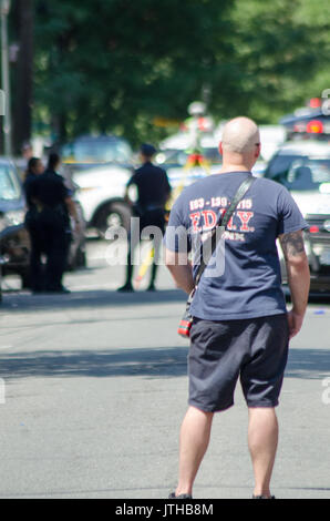 E 229 st Ed Carpenter street, Bronx, New York, Stati Uniti d'America. Il 9 agosto, 2017.un vigile del fuoco guarda come condotta da parte della polizia di un inchiesta sugli incidenti per un ambulette che appoggiato su una donna che era il funzionamento del veicolo in corrispondenza di E 229 st Ed Carpenter street. Michael Glenn / Alamy Live News Foto Stock