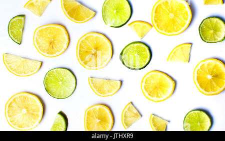 Limone e fettine di lime su sfondo bianco Foto Stock