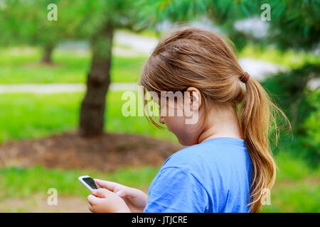 Bella ragazza che gioca sul telefono su strada Foto Stock