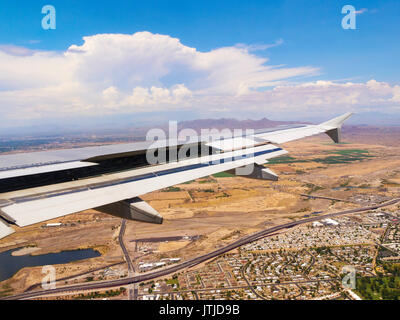 Airbus A320 ala con spoiler di volo e lembi posteriori parzialmente dispiegato sull approccio all'Aeroporto Internazionale Sky Harbor di Phoenix. Distanza temporale. Foto Stock