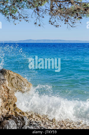 Sea Wave è rotto su pietre. Foto Stock