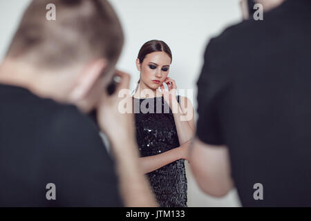 Fotografi paparazzi prendere le foto di donna in abiti da cocktail. Foto Stock