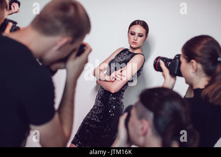 Fotografi paparazzi prendere le foto di donna in abiti da cocktail. Foto Stock