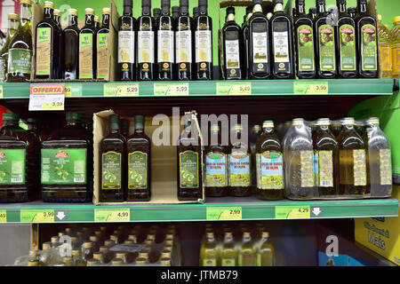 Varietà di marche di olio d'oliva italiano in bottiglie su scaffale di supermercato, Italia Foto Stock