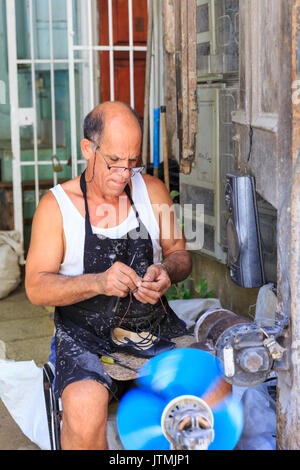 Uomo che ripara le scarpe della strada, in scena a La Habana Vieja, Old Havana, Cuba Foto Stock