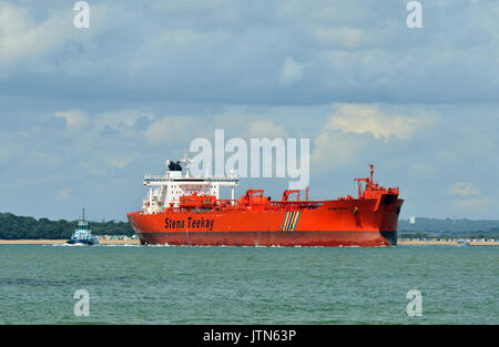 Una grande stena teekay petroliera di lasciare il porto di Southampton o fawley raffineria di petrolio con un rimorchiatore attaccato alla parte posteriore scortare la nave. Foto Stock