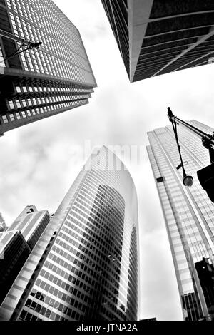 Grattacieli di vetro contro il cielo nuvoloso nella città di Chicago, Illinois, Stati Uniti d'America. Bianco e nero astratto vista verso l'alto del centro cittadino di grattacieli. Foto Stock