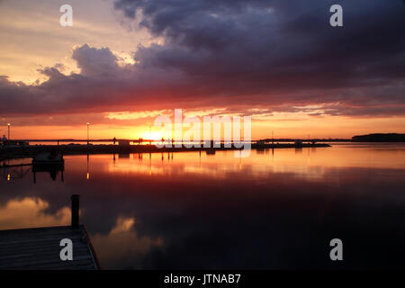 Bellissimo paesaggio con tramonto dorato dopo sera storm su un lago Mendota nella città di Madison, Wisconsin, Stati Uniti d'America. Esposizione lunga inquadratura orizzontale. Foto Stock