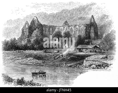 1870: Tintern Abbey, fondata il 9 maggio 1131, visto dal fiume Wye, che forma il confine tra Monmouthshire in Galles e Gloucestershire in Inghilterra. Fu solo la seconda fondazione cistercense in Gran Bretagna e la prima in Galles. Cade in rovina dopo la dissoluzione dei monasteri nel XVI secolo, i resti sono stati celebrati in poesia e spesso dipinto da visitatori dal XVIII secolo in poi. Monmouthshire, Wales, Regno Unito. Foto Stock