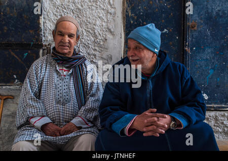 Il Marocco, Africa: vecchi uomini musulmani seduti in stretti vicoli di Tangeri, il marocchino città sulla costa del Maghreb con la sua miscela unica di culture Foto Stock