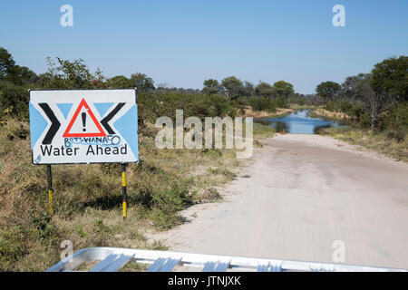 Cartello stradale di avvertimento di un invaso la strada nel nord del Botswana Foto Stock