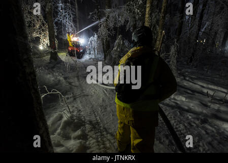 Un team di ricercatori la replica di una tempesta di ghiaccio durante l'inverno nelle White Mountains del New Hampshire. Il team sta studiando gli effetti delle tempeste di ghiaccio sul terreno, gli alberi, uccelli ed insetti. Foto Stock