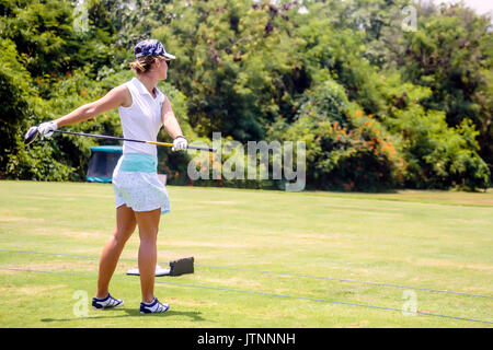 Giovane donna giocando a golf, Bali, Indonesia Foto Stock