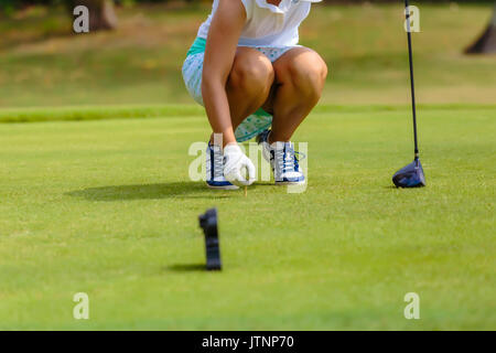 Giovane donna posizionando la pallina da golf sul raccordo a T Foto Stock