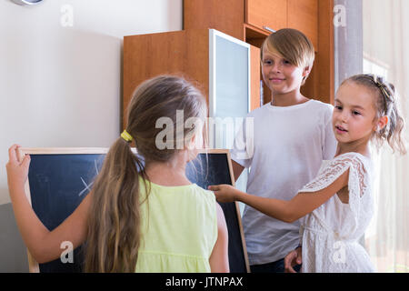 Smart bambini a giocare a tic-tac-toe in salotto Foto Stock