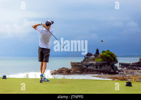 Giovane uomo giocando a golf, Bali, Indonesia Foto Stock