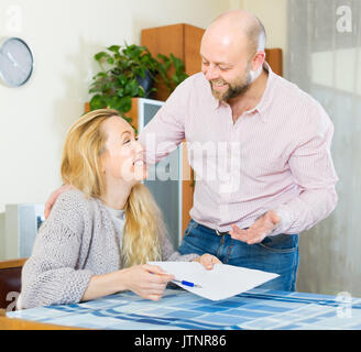 Allegro sorridente giovane di discutere i dettagli del matrimonio insediamento a casa Foto Stock