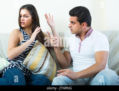 Grave conversazione tra arrabbiato marito ed il suo attraente giovane moglie a casa Foto Stock