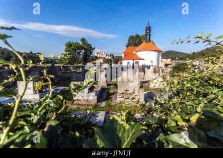 Cimitero rurale con una piccola chiesa, sullo sfondo Castello di Rabi, Repubblica Ceca Foto Stock