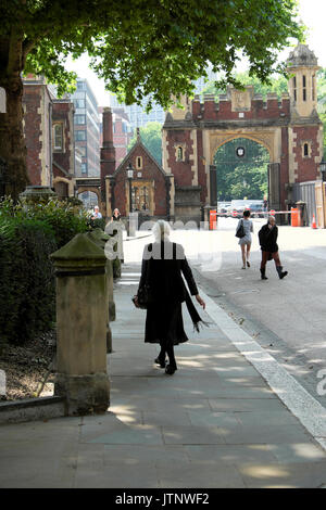 Vista posteriore di una donna matura vestita di nero camminando attraverso la nuova piazza nei pressi di Lincolns Inn Fields a Holborn London, England Regno Unito KATHY DEWITT Foto Stock