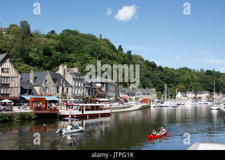 La Francia. La Bretagna. Dinan. Harbourside case e ristoranti sul fiume Rance con turisti in canoa e barca a motore. Foto Stock