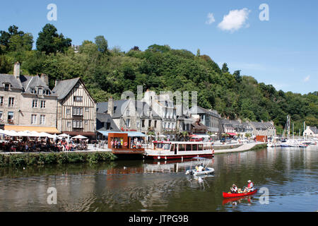 La Francia. La Bretagna. Dinan. Harbourside case e ristoranti sul fiume Rance con turisti in canoa e barca a motore. Foto Stock