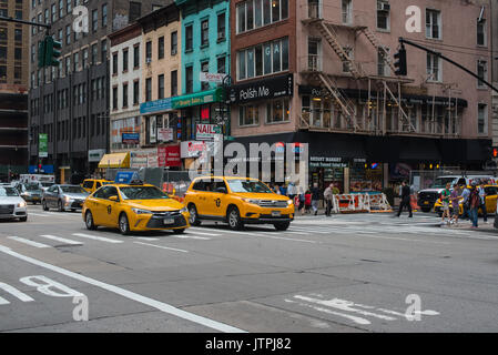 Due cabine gialle conducono il traffico sulla 6th Avenue in New York City. Solo uso editoriale Foto Stock