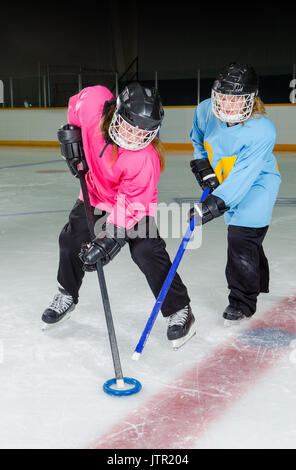 Due ragazze lottare per la corona, Ringette canadesi è un ice sport giocato in una pista da hockey o arena. Foto Stock