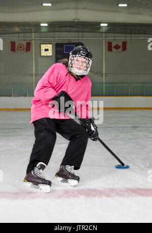 Un Tween Ringette Player in azione in pista da hockey Foto Stock