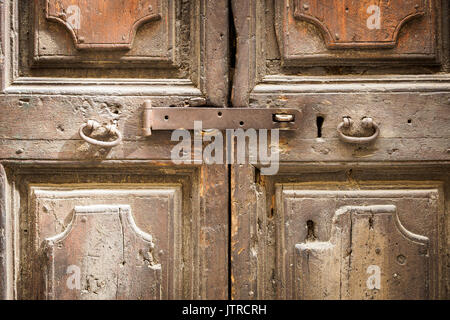 Vecchio arrugginito chiavistello close up su una antica porta in legno con maniglie in metallo. Foto Stock