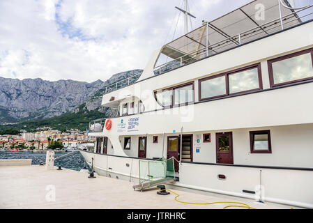 Imbarcazione da diporto con allegro turisti entra nel porto di Makarska, Croazia. Foto Stock