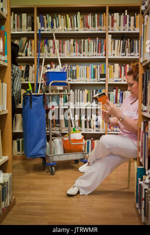 Il detergente divertente leggere un libro in una libreria, Andalusia, Spagna Foto Stock