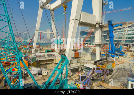 HONG KONG, CINA - 26 gennaio 2017: sito in costruzione del molo, con diverse macchine in una giornata di sole, di Hong Kong e la Cina con una città in horizont Foto Stock