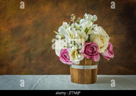 Rose bianche e viola artificiale di rose su sfondo bianco con spazio per l'immissione di testo. Foto Stock