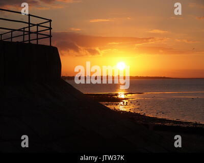 Sheerness, Kent. 10 Ago, 2017. Regno Unito Meteo: uno splendido tramonto dorato e sky ha segnato la fine della giornata. Credito: James Bell/Alamy Live News Foto Stock