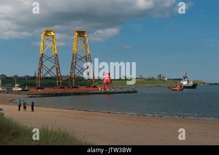 Fiume Tyne, South Shields, Regno Unito, 10 agosto 2017. Turbina eolica fondazioni trainato passato il Groyne, South Shields sul loro modo al Beatrice offshore wind farm in Moray Firth. A causa della loro altezza griglia nazionale ha dovuto aumentare l'altezza dei cavi di alimentazione attraverso il Fiume Tyne nonostante i piloni essendo due dei più alti in Gran Bretagna, superata solo da gruppi che attraversano il fiume Tamigi vicino a Londra e il fiume Severn a Bristol. Credito: Colin Edwards/Alamy Live News. Foto Stock