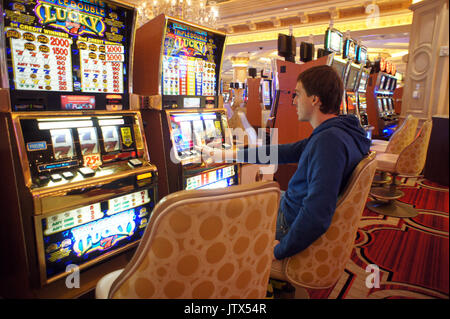 L'uomo gioca slot machine Foto Stock