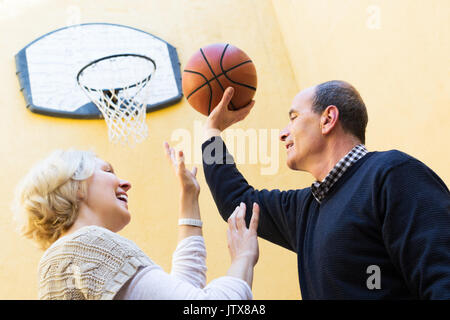 Sorridente Coppia matura appoggiata contro la scalinata interna Foto Stock