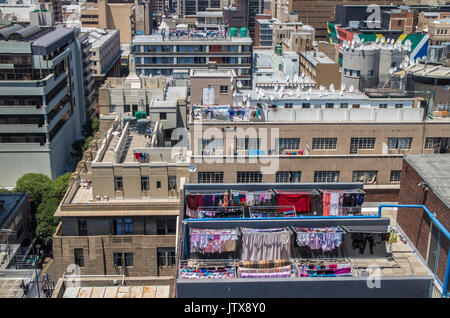 Servizio lavanderia interna di abitanti delle città appeso fuori in una giornata di sole su una miriade di linee di lavaggio su edificio di appartamenti tetti nel centro di Johannesburg Foto Stock