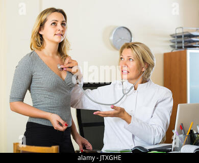 Anziani medico in bianco il controllo globale dei polmoni dei malati paziente femmina in cliniche Foto Stock