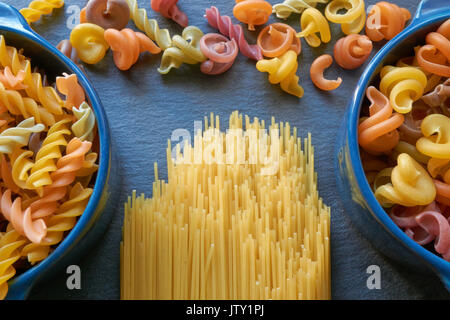 La pasta italiana in forme differenti. diritta, spirale, conchiglie di mare sul nero ardesia Foto Stock