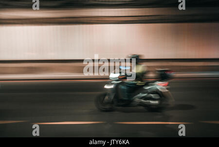 Londra, Inghilterra - Luglio 26, 2017 : intenzionalmente immagine sfocata di un uomo in sella a una moto sotto un ponte di Londra Foto Stock