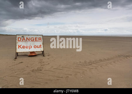 Pericolo Tenere fuori segno sulla spiaggia vuota di avvertimento di armi sul collaudo Pendine Sands, Carmarthenshire, Galles Foto Stock