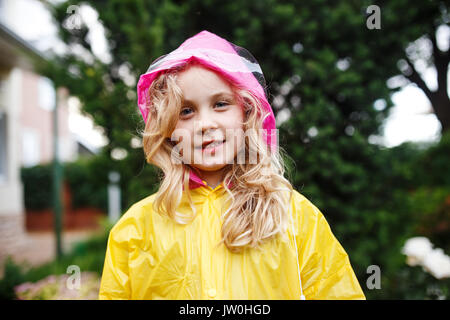 Felice piccolo bambino ragazza in impermeabile giallo Foto Stock