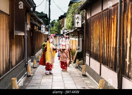 Il gruppo di quattro Geisha prendendo un selfie in una tradizionale strada di Kyoto in Giappone Foto Stock