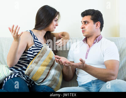 Grave conversazione tra offeso il marito e la sua attraente giovane moglie a casa Foto Stock