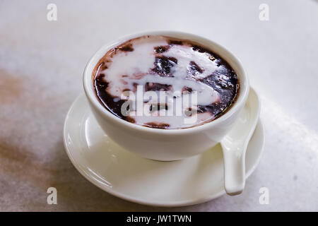 Singapore Bubur dessert tigrato Hitam, nero riso dolce con il latte di cocco e zucchero di palma, in inglese chiamato Black riso glutinoso porridge Foto Stock