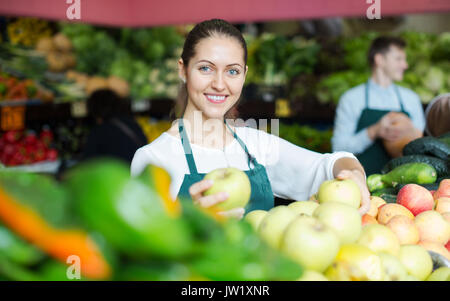 Giovani roba sorridente in vendita della catenaria dolce di mele stagionale al marketplace Foto Stock